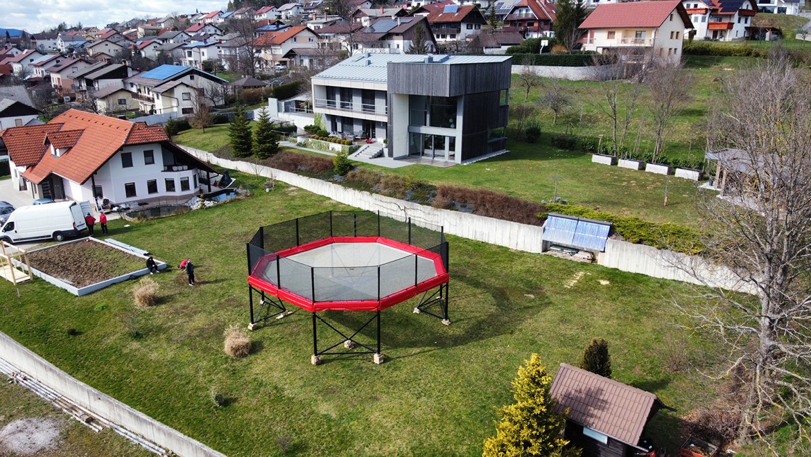 MegaTramp trampoline setup in green park with scenic mountain view